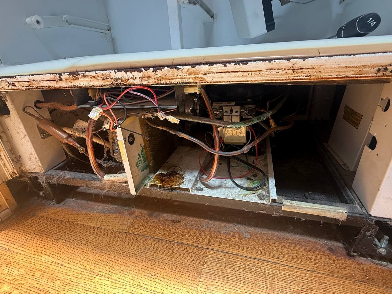 Rusted cabinet interior and corroded wiring on a 1991 Sub-Zero 501F before a sealed-system rebuild